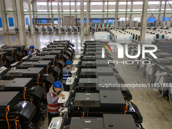 Workers debug smart mobile charging piles at Nantong Guoxuan New Energy Technology Co., LTD., located in Nantong High-tech Zone, East China'...