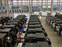 Workers debug smart mobile charging piles at Nantong Guoxuan New Energy Technology Co., LTD., located in Nantong High-tech Zone, East China'...