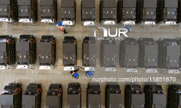 Workers debug smart mobile charging piles at Nantong Guoxuan New Energy Technology Co., LTD., located in Nantong High-tech Zone, East China'...