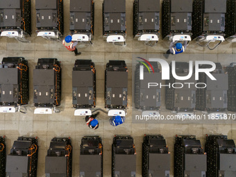 Workers debug smart mobile charging piles at Nantong Guoxuan New Energy Technology Co., LTD., located in Nantong High-tech Zone, East China'...