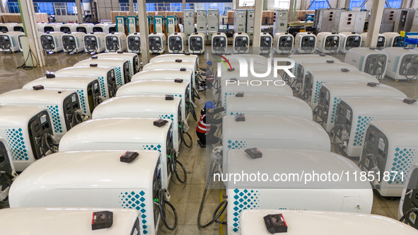 Workers debug smart mobile charging piles at Nantong Guoxuan New Energy Technology Co., LTD., located in Nantong High-tech Zone, East China'...