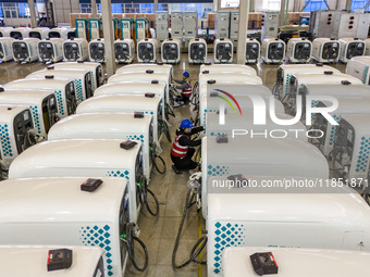 Workers debug smart mobile charging piles at Nantong Guoxuan New Energy Technology Co., LTD., located in Nantong High-tech Zone, East China'...