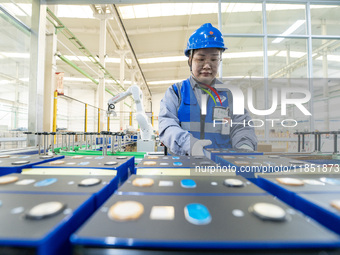 A worker produces energy storage batteries at Nantong Guoxuan New Energy Technology Co., Ltd. in Nantong High-tech Zone, East China's Jiangs...