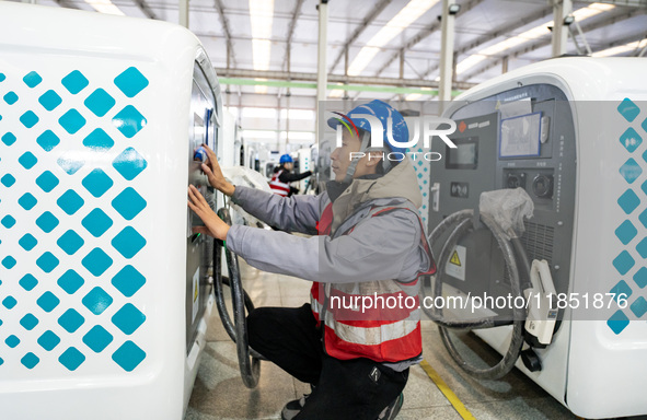 A worker debugs an intelligent mobile charging station at Nantong Guoxuan New Energy Technology Co., Ltd. in Nantong High-tech Zone, East Ch...