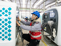 A worker debugs an intelligent mobile charging station at Nantong Guoxuan New Energy Technology Co., Ltd. in Nantong High-tech Zone, East Ch...