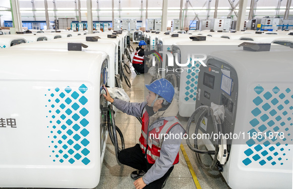 A worker debugs an intelligent mobile charging station at Nantong Guoxuan New Energy Technology Co., Ltd. in Nantong High-tech Zone, East Ch...