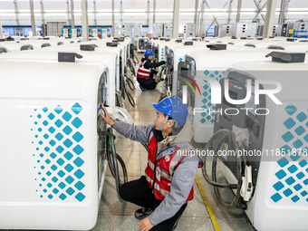 A worker debugs an intelligent mobile charging station at Nantong Guoxuan New Energy Technology Co., Ltd. in Nantong High-tech Zone, East Ch...