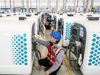 A worker debugs an intelligent mobile charging station at Nantong Guoxuan New Energy Technology Co., Ltd. in Nantong High-tech Zone, East Ch...