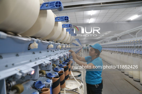 A worker works at a textile workshop of Xinjiang Jingyi Textile Technology Co., Ltd. in Aksu prefecture, Northwest China's Xinjiang Uygur au...