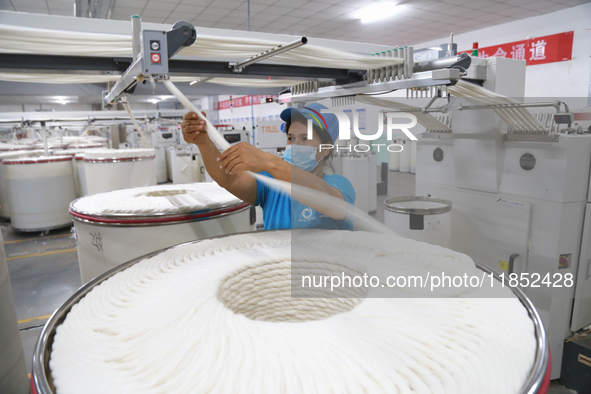 A worker works at a textile workshop of Xinjiang Jingyi Textile Technology Co., Ltd. in Aksu prefecture, Northwest China's Xinjiang Uygur au...