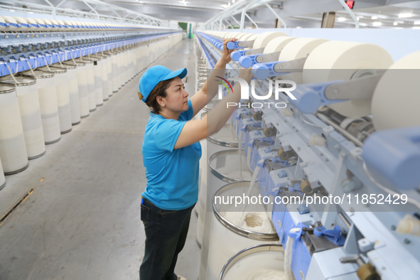 A worker works at a textile workshop of Xinjiang Jingyi Textile Technology Co., Ltd. in Aksu prefecture, Northwest China's Xinjiang Uygur au...