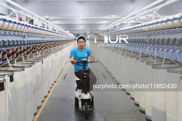 A worker works at a textile workshop of Xinjiang Jingyi Textile Technology Co., Ltd. in Aksu prefecture, Northwest China's Xinjiang Uygur au...