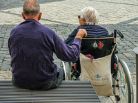 In Coburg, Germany, on September 19, 2021, an elderly man and woman share a quiet moment together in an urban square. The woman, seated in a...