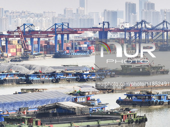 Cargo ships load and unload containers at the Port of Huai'an in Jiangsu province, China, on December 10, 2024. (