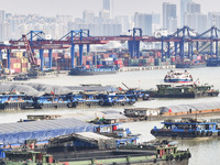 Cargo ships load and unload containers at the Port of Huai'an in Jiangsu province, China, on December 10, 2024. (