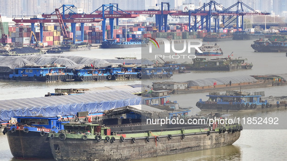 Cargo ships load and unload containers at the Port of Huai'an in Jiangsu province, China, on December 10, 2024. 