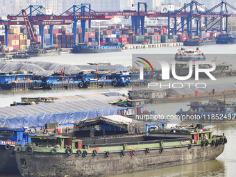 Cargo ships load and unload containers at the Port of Huai'an in Jiangsu province, China, on December 10, 2024. (