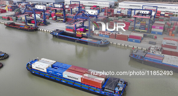 Cargo ships load and unload containers at the Port of Huai'an in Jiangsu province, China, on December 10, 2024. 