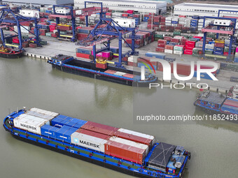 Cargo ships load and unload containers at the Port of Huai'an in Jiangsu province, China, on December 10, 2024. (