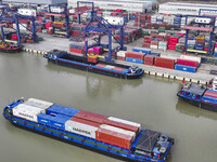 Cargo ships load and unload containers at the Port of Huai'an in Jiangsu province, China, on December 10, 2024. (