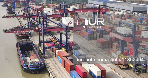 Cargo ships load and unload containers at the Port of Huai'an in Jiangsu province, China, on December 10, 2024. 