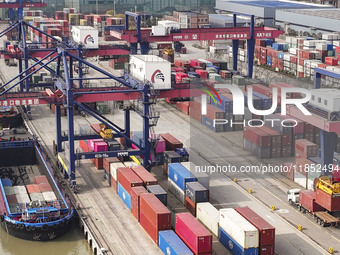 Cargo ships load and unload containers at the Port of Huai'an in Jiangsu province, China, on December 10, 2024. (