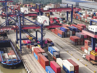 Cargo ships load and unload containers at the Port of Huai'an in Jiangsu province, China, on December 10, 2024. (