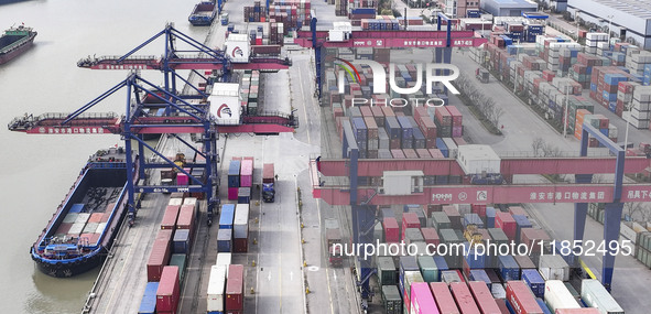 Cargo ships load and unload containers at the Port of Huai'an in Jiangsu province, China, on December 10, 2024. 