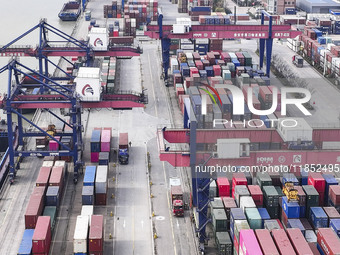 Cargo ships load and unload containers at the Port of Huai'an in Jiangsu province, China, on December 10, 2024. (