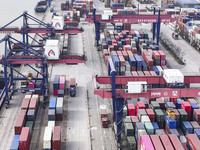 Cargo ships load and unload containers at the Port of Huai'an in Jiangsu province, China, on December 10, 2024. (