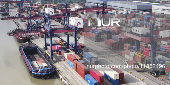 Cargo ships load and unload containers at the Port of Huai'an in Jiangsu province, China, on December 10, 2024. 