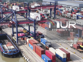 Cargo ships load and unload containers at the Port of Huai'an in Jiangsu province, China, on December 10, 2024. (