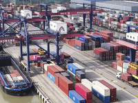 Cargo ships load and unload containers at the Port of Huai'an in Jiangsu province, China, on December 10, 2024. (