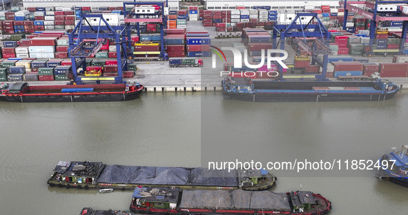 Cargo ships load and unload containers at the Port of Huai'an in Jiangsu province, China, on December 10, 2024. 