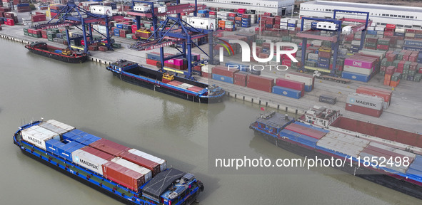 Cargo ships load and unload containers at the Port of Huai'an in Jiangsu province, China, on December 10, 2024. 