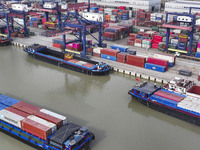 Cargo ships load and unload containers at the Port of Huai'an in Jiangsu province, China, on December 10, 2024. (