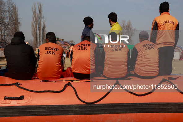 State Disaster Response Fund team members sit on a boat as they wait to start a mock drill session in Baramulla, Jammu and Kashmir, India, o...