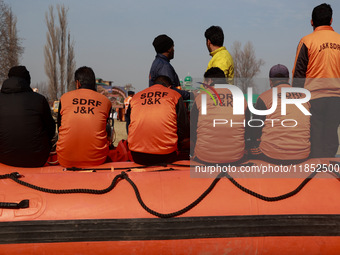 State Disaster Response Fund team members sit on a boat as they wait to start a mock drill session in Baramulla, Jammu and Kashmir, India, o...