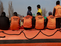 State Disaster Response Fund team members sit on a boat as they wait to start a mock drill session in Baramulla, Jammu and Kashmir, India, o...