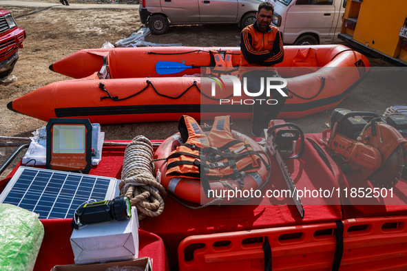 A State Disaster Response Fund team member sits on a boat as they wait to start a mock drill session in Baramulla, Jammu and Kashmir, India,...