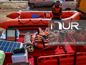 A State Disaster Response Fund team member sits on a boat as they wait to start a mock drill session in Baramulla, Jammu and Kashmir, India,...