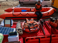 A State Disaster Response Fund team member sits on a boat as they wait to start a mock drill session in Baramulla, Jammu and Kashmir, India,...