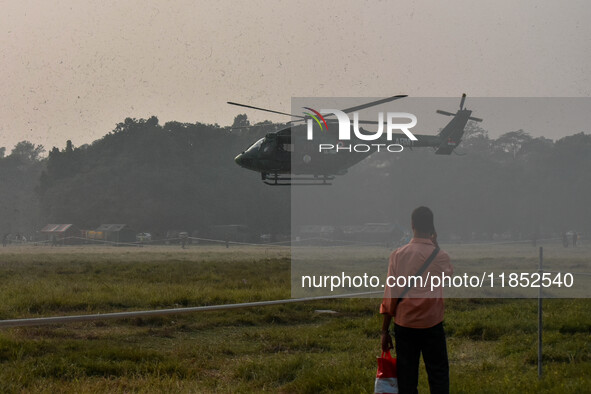 People watch Indian Army helicopters during a practice run for the upcoming Vijay Diwas celebrations in Kolkata, India, on December 10, 2024...