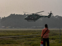 People watch Indian Army helicopters during a practice run for the upcoming Vijay Diwas celebrations in Kolkata, India, on December 10, 2024...