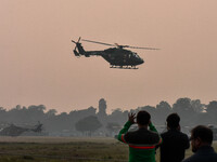 People watch Indian Army helicopters during a practice run for the upcoming Vijay Diwas celebrations in Kolkata, India, on December 10, 2024...