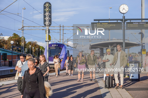 People are on the railway train station deck in Ystad, Sweden, on August 4, 2024. 