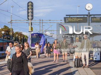 People are on the railway train station deck in Ystad, Sweden, on August 4, 2024. (