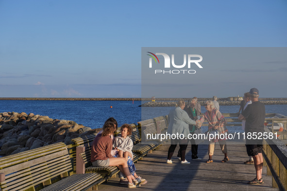 People meet on the promenade in Ystad, Sweden, on August 4, 2024 