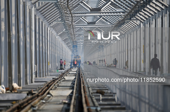 Labourers work on a newly constructed Ganga Rail Bridge built over the river Ganges at the Sangam area in Prayagraj, India, on December 10,...