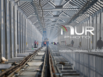 Labourers work on a newly constructed Ganga Rail Bridge built over the river Ganges at the Sangam area in Prayagraj, India, on December 10,...